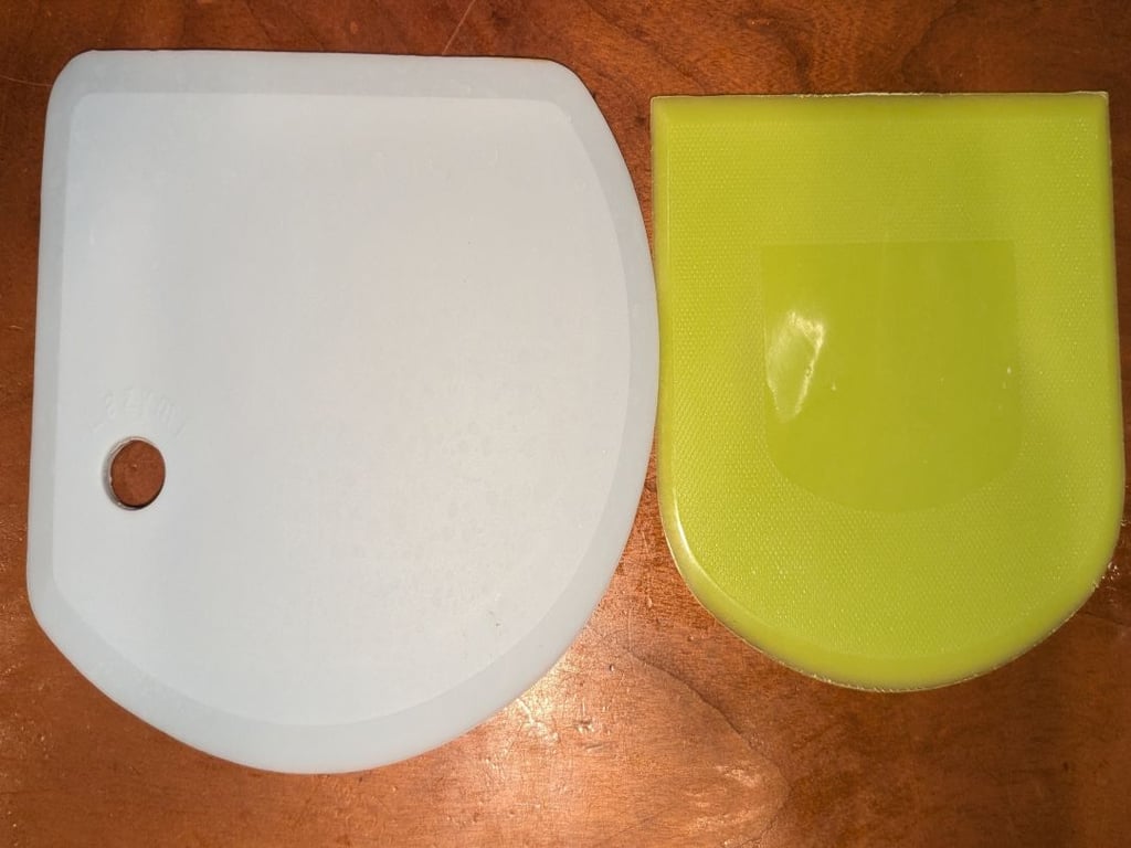 The white scraper has the metal piece on the inside